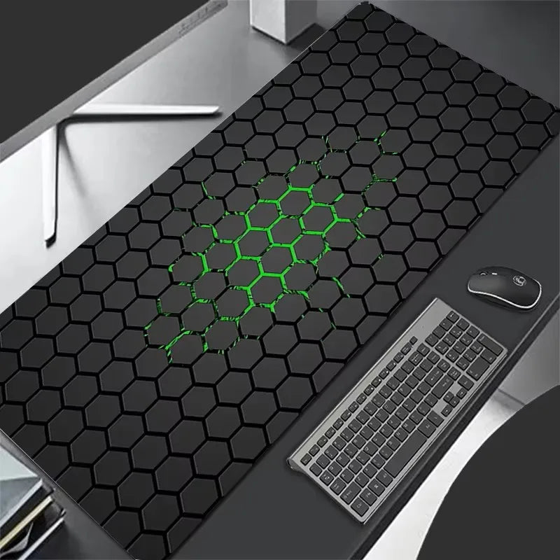 Black hexagonal patterned desk mat with green accents on a desk with keyboard and mouse.