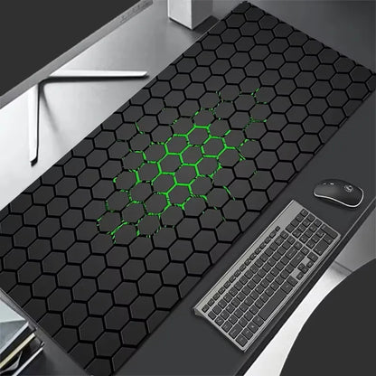 Black hexagonal patterned desk mat with green accents on a desk with keyboard and mouse.